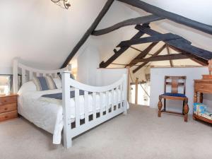 una camera con un letto bianco e una culla di The Annexe - Tbh a Crackington Haven
