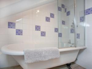 Crackington HavenにあるThe Annexe - Tbhの白いバスルーム(バスタブ、ガラス張りのシャワー付)