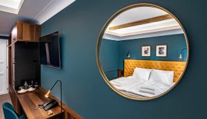 una camera da letto con specchio su una parete blu di Palatinus Boutique Hotel a Pécs