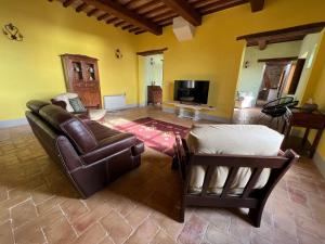 - un salon avec un canapé et une télévision dans l'établissement Villa Gosparini, à Lisciano Niccone
