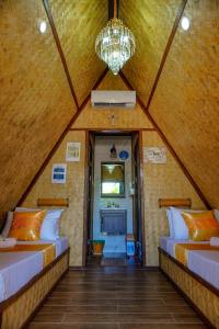 Zimmer im Dachgeschoss mit 2 Betten und einem Kronleuchter in der Unterkunft Rock Island Eres Bella in Buenavista