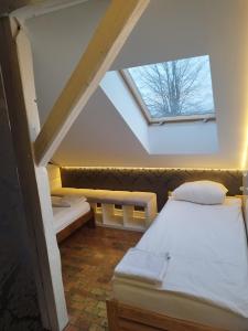 Zimmer im Dachgeschoss mit 2 Betten und einem Dachfenster in der Unterkunft Apartament z widokiem Słubice in Słubice