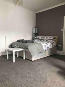 a white bedroom with a bed and a table at Studio3 Ave house in Scarborough