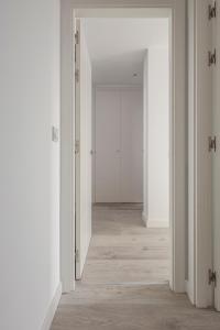 an empty hallway with white walls and wooden floors at Uxama Sevilla Luxury Penthouse en Triana - Terraza y parking privados - piscina in Seville