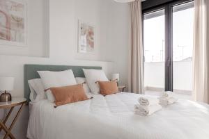 Un dormitorio con una cama blanca con dos ositos de peluche. en Uxama Sevilla Luxury Penthouse en Triana - Terraza y parking privados - piscina en Sevilla