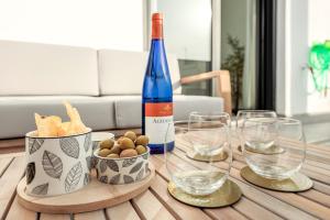 a bottle of wine and glasses on a table at Uxama Sevilla Luxury Penthouse en Triana - Terraza y parking privados - piscina in Seville