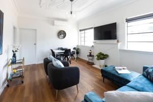 a living room with a couch and a table at Art deco inner city comfort in Bendigo