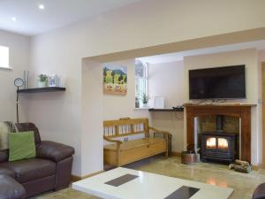 a living room with a couch and a fireplace at Morton Grange Coach House - E5557 in Ellesmere