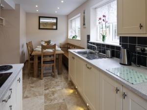 uma cozinha com uma mesa e uma sala de jantar em Morton Grange Coach House - E5557 em Ellesmere