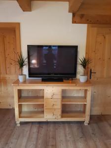 a flat screen tv sitting on top of a wooden entertainment center at Sonnleit'n Zimmer 1 in Abtenau