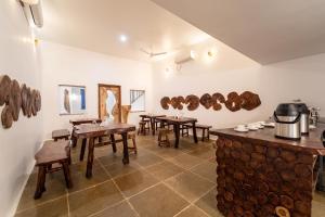 a room with wooden tables and wooden chairs and a counter at Conch Resort Luxury Private Pool Suites in Puducherry