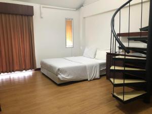 a bedroom with a bed and a spiral staircase at Floral Shire Suvarnabhumi Airport - SHA Extra Plus in Lat Krabang