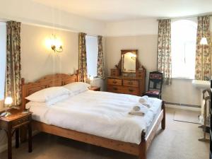 a bedroom with a large bed and a mirror at Coach House in Loddiswell