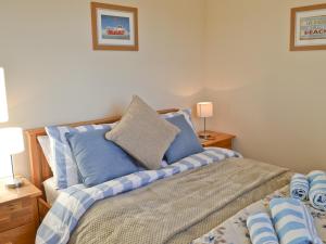 ビードネルにあるJimbowのベッドルーム1室(青と白の枕が備わるベッド1台付)