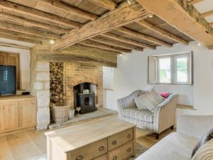 ein Wohnzimmer mit einem Kamin und einem Sofa in der Unterkunft Tom Cottage in Wing