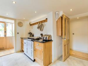 a kitchen with wooden cabinets and a counter top at Tom Cottage in Wing