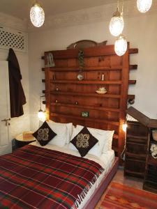 - une chambre avec un lit doté d'une grande tête de lit en bois dans l'établissement Riad Laly Tourisme Eclairé Le bijou de la medina, à Marrakech