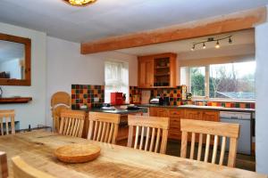 a kitchen with a wooden table and wooden chairs at Netherend in Threlkeld
