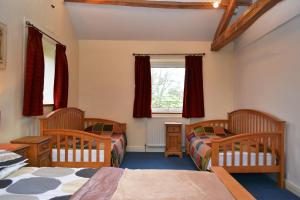 a bedroom with three beds and a window at Netherend in Threlkeld