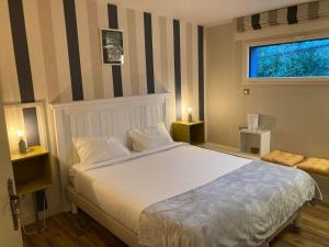 Un dormitorio con una cama grande y una ventana en Chambres d’hôtes Nordlys, en Pluneret
