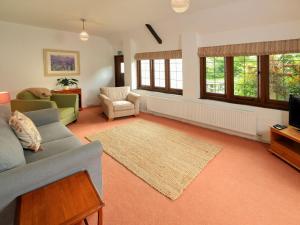 a living room with a couch and a tv at Old Chapel Cottage in Dunster