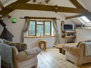 a living room with two couches and a tv at The Garden Barn in Ivybridge