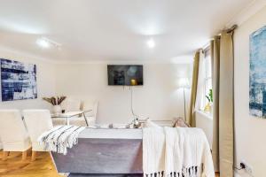 a room with a bathtub and a table and chairs at Park Lane Apartments Marble Arch in London