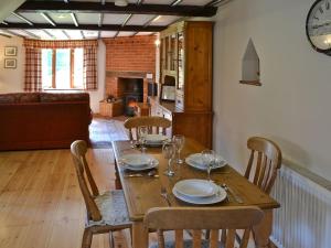 een houten tafel met stoelen en een eetkamer bij The Cottage in Great Ellingham