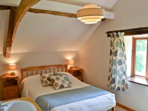 een slaapkamer met een bed, een wastafel en een raam bij The Cottage in Great Ellingham