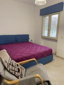 a bedroom with a bed with a purple blanket at Villino Monte Sant'Angelo in Otranto