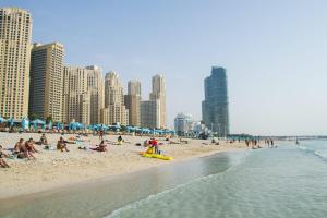 a group of people on a beach with buildings at Luxury JBR · Marina View · 5* Beach Resorts Access in Dubai