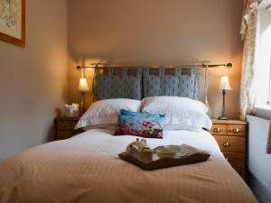 a bed with a tray of food on top of it at The Coach House in Great Malvern