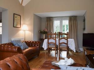 ein Wohnzimmer mit einem Sofa und einem Tisch in der Unterkunft The Coach House in Great Malvern