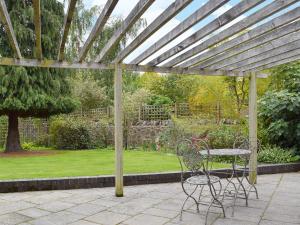 a patio with a table and chairs under a pergola at The Coach House in Great Malvern