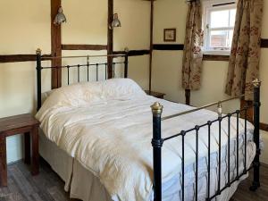 um quarto com uma cama grande e lençóis brancos em Orchard Bank Cottage em Longhope