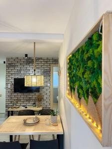 シュツァブニツァにあるMoje Pieniny Apartamentの食卓と植物に覆われた壁