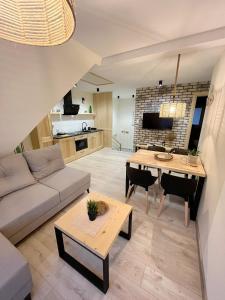 een woonkamer met een bank en een tafel bij Moje Pieniny Apartament in Szczawnica