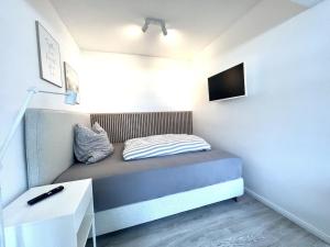 a small room with a bed and a tv at NEU! ERSTBEZUG! Vollsanierte Fewo mit Blick auf die Flensburger Förde in Harrislee