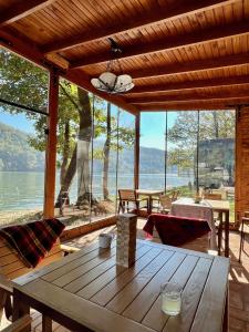 una mesa de madera en una habitación con vistas al agua en Nautica Bahna, en Orşova