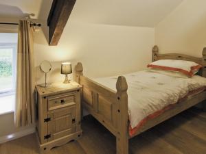 a bedroom with a bed and a dresser with a mirror at The Coach House - Hw7593 in Bettws-yn-Rhôs