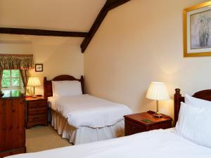 a bedroom with two beds and two lamps at Primula Patch-mjc in Akeld