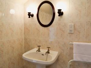 a bathroom with a sink and a mirror on the wall at Primula Patch-mjc in Akeld