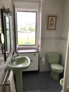 bagno con lavandino, servizi igienici e finestra di Casa en Castanedo: Casa El Solarón a Castanedo