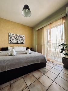 1 dormitorio con cama grande y ventana grande en Cozy Apartments Mc Queen en Athens