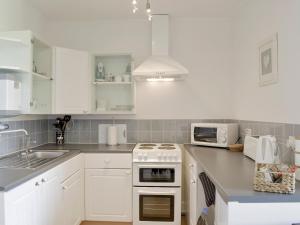 een keuken met witte kasten en een witte kookplaat bij St Martins Square Apartment 2 in Scarborough