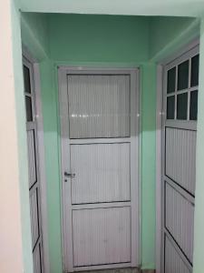 2 puertas de garaje en una habitación con paredes verdes en CASA EN CORRIENTES 2 HAB para 5 PERSONAS en Corrientes