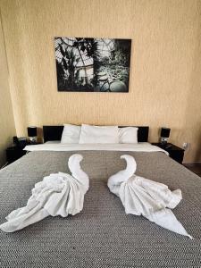 2 cisnes toalhas numa cama num quarto em Cozy Apartments Mc Queen em Atenas