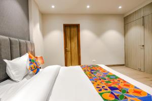 Un dormitorio con una cama con una manta de colores. en FabHotel Prime K9 Grand, en Ludhiana