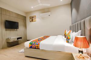 a hotel room with a bed and a television at FabHotel Prime K9 Grand in Ludhiana