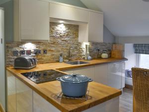a kitchen with a stove with a pot on the counter at Alnwick Loft in Alnwick